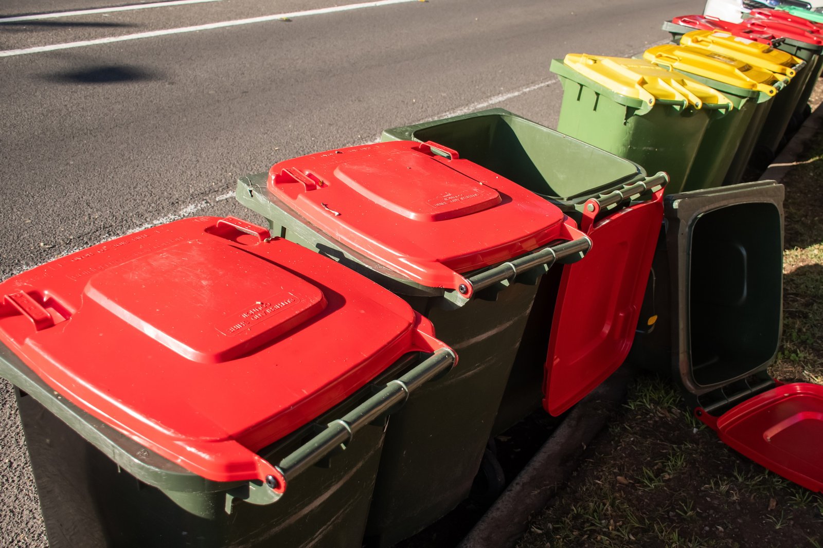 Wheelie bins for household rubbish garbage waste lined up on the street after council collection